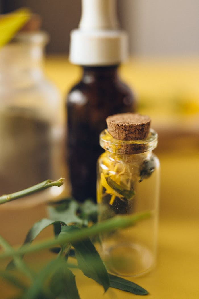 Glass bottles with herbs on a wooden surface showcasing natural remedies.